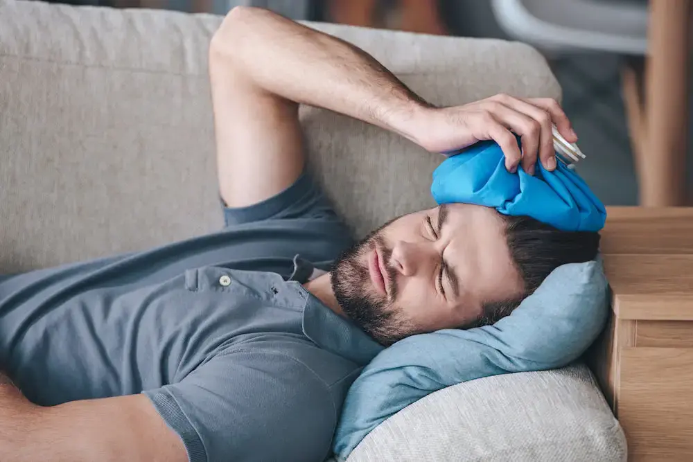 A man holding a hot water bottle on his head