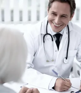 A doctor speaking with a patient and smiling