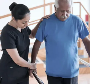 A physical therapist supporting a man as he walks