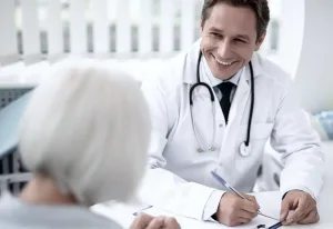 A doctor speaking with a patient and smiling